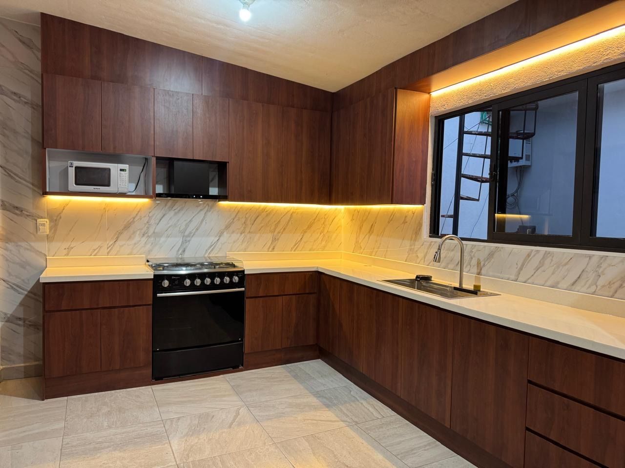 Cocina a la medida con iluminación cálida bajo los gabinetes