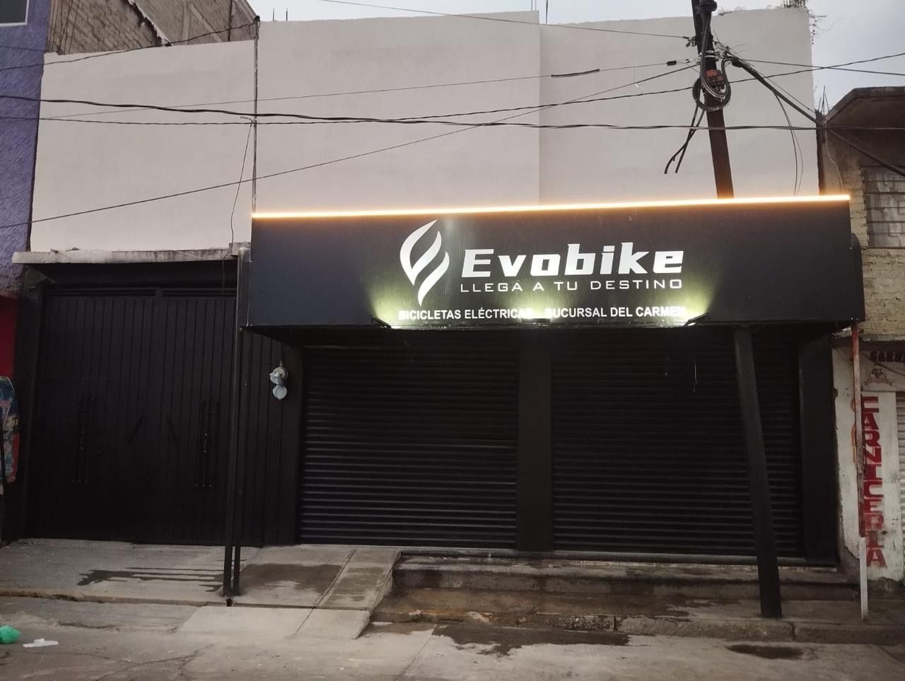 Fachada de tienda con letrero iluminado