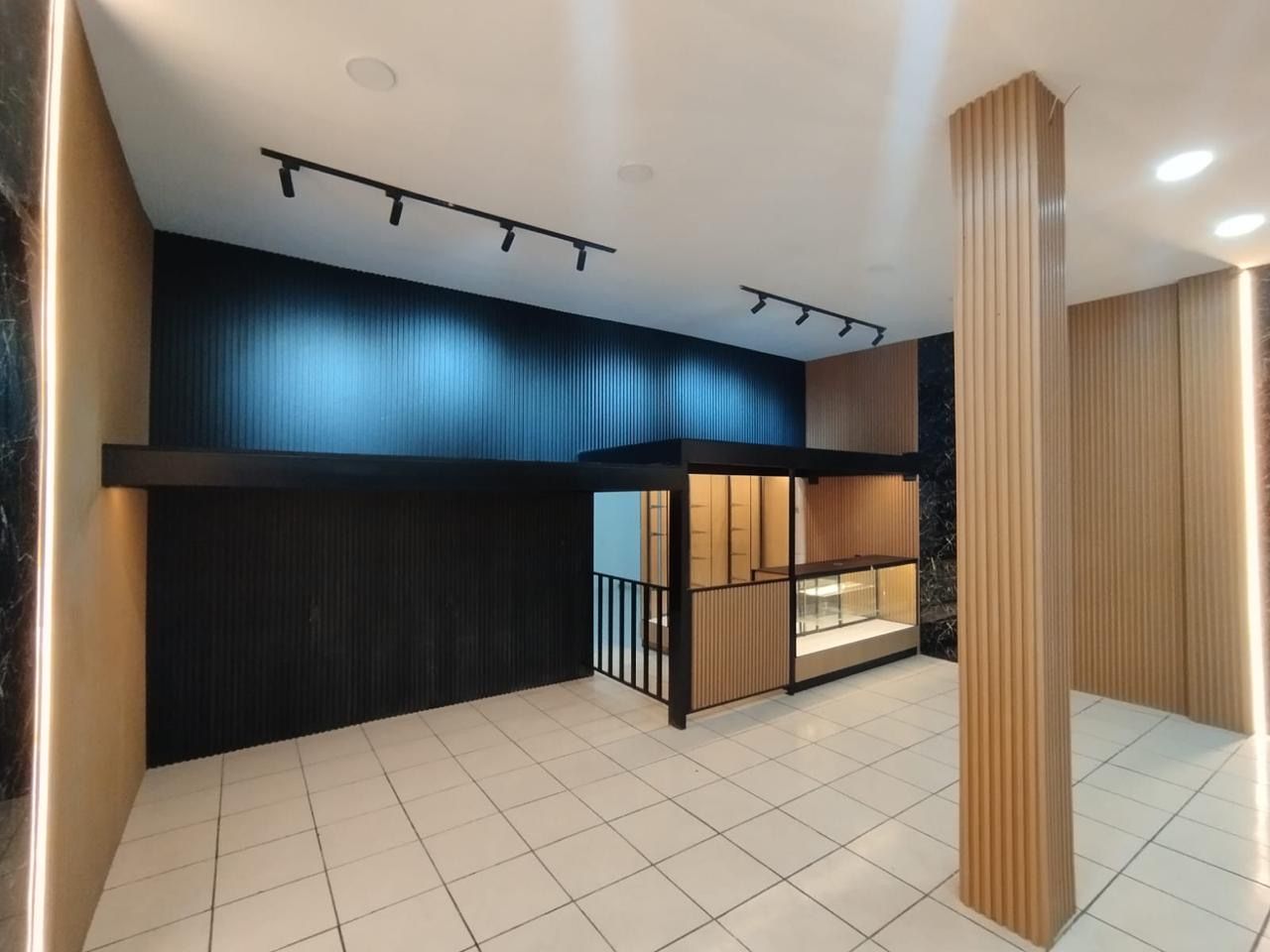Interior de tienda con muro ranurado y rieles de iluminación