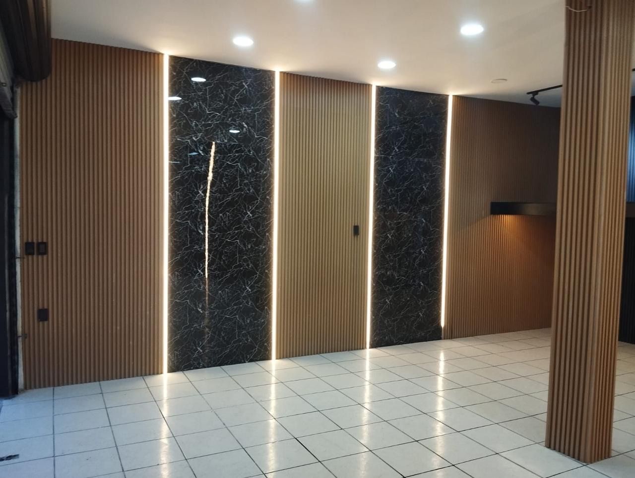 Muro con paneles ranurados, paneles negros y líneas de luz